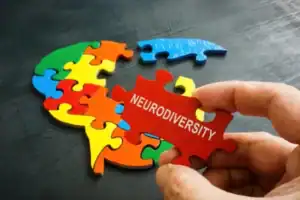 Colorful puzzle pieces with one labeled 'Neurodiversity' for autism awareness.